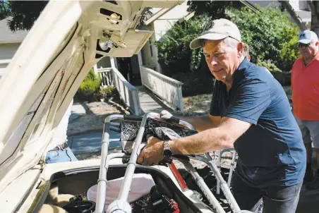  ?? Photos by Michael Short / Special to The Chronicle ?? David Woltering loads a walker into the back of a car as he helps evacuate people from an elderly care home in Windsor.