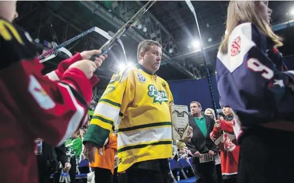  ?? KAYLE NEIS/THE CANADIAN PRESS ?? Scott Thomas holds the urn with the ashes of his son, Evan, as he walks into the funeral for the Humboldt Broncos player Monday at SaskTel Centre, where Evan was eulogized as fun and gifted.