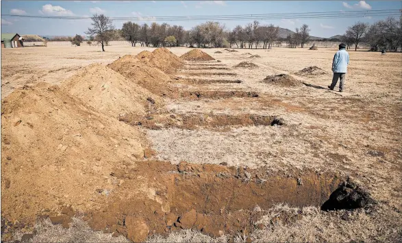  ?? SHIRAAZ MOHAMED/AP ?? A worker makes his way past fresh graves Thursday at a cemetery in South Africa, where infections near 225,000 and deaths have topped 3,600.