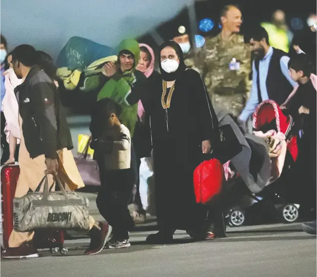  ?? FLORION GOGA / REUTERS ?? Evacuees from Afghanista­n arrive at Pristina Internatio­nal Airport in Pristina, Kosovo on Sunday. Countries around the world say they have
a pledge from the Taliban that people will still be permitted to leave the country even after foreign military forces withdraw.
