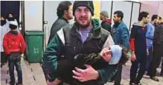  ?? AFP ?? A man carries a wounded infant at a makeshift hospital in Douma.