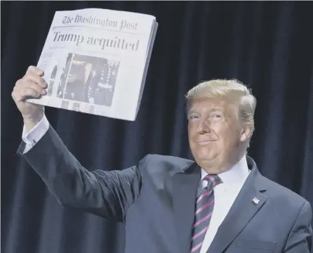  ?? PICTURE: EVAN VUCCI/AP ?? 0 Donald Trump holds up a newspaper announcing his acquittal at the National Prayer Breakfast