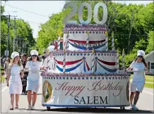  ?? SARAH GORDON/THE DAY ?? Parade walkers push a birthday cake float to mark Salem’s bicentenni­al during the town’s Memorial Day parade Monday.