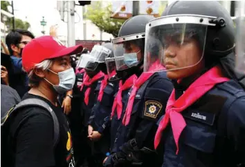  ?? — Reuters ?? A pro-democracy protester stands in front of police officers during anti-government protests in Bangkok.