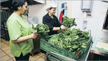  ?? CRISTINA GALLEGO ?? Dos de las cocineras del comedor social de Canpedró reciben las acelgas recién recolectad­as