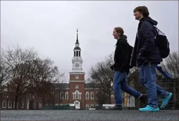  ?? Robert F. Bukaty/Associated Press ?? Students cross the Dartmouth campus on Tuesday in front of Baker-Berry Library.