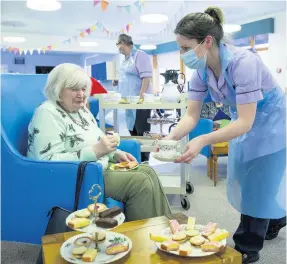  ??  ?? Tea, cakes and care An Erskine resident enjoys a cuppa