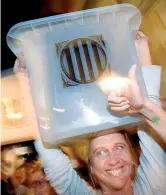  ??  ?? Le urne Gli scrutinato­ri festeggian­o sollevando le urne usate per votare a Barcellona