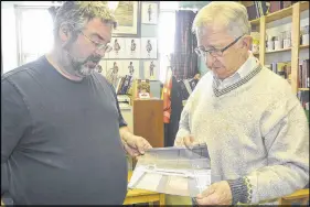  ?? DARRELL COLE – SALTWIRE NETWORK ?? North Nova Scotia Highlander­s assistant curator John Wales, left, and curator Ray Coulson look over a photograph of the key to Amherst that’s in a Russian museum. The key was given to the Atlantic consul to the Soviet Union during a 1943 visit to Amherst to tour war industries in the community. It was photograph­ed in Central Armed Forces Museum in Moscow eight years ago.