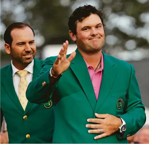  ?? David J. Phillip / Associated Press ?? From the perspectiv­e of Spain’s Sergio Garcia, left, who won last year’s Masters jacket, Captain America, aka Patrick Reed, looks good in green.