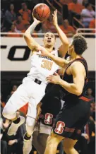  ?? Nate Billings / Associated Press ?? Oklahoma State’s Jeffrey Carroll shoots over Stanford’s Reid Travis.