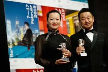  ?? — AFP photo ?? Chinese actor Wang Jingchun and Chinese actress Yong Mei pose with their Silver bears for Best Actors in the film ‘Di Jiu Tian Chang' (So Long, My Son) during a press conference following the awards ceremony of the 69th Berlinale film festival on Saturday in Berlin.