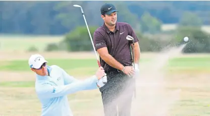  ?? Picture: Getty. ?? Patrick Reed watches Belgium’s Nicolas Colsaerts shoot out of bunker in practice for the Scottish Open at Gullane.