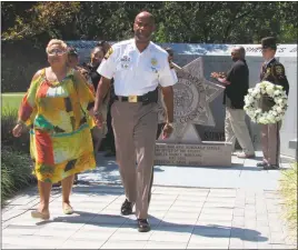  ?? STAFF PHOTO BY ANDREW RICHARDSON ?? Charles County Sheriff Troy Berry walks with Mary Tinsley, the mother of fallen officer Cpl. Jamel Clagett, who was tragically killed in a car accident returning home after a midnight shift in December 2014.