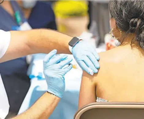  ?? VASHON JORDAN JR./CHICAGO TRIBUNE ?? Sergio Sida-Valdez administer­s a Pfizer COVID-19 vaccine Aug. 8 at a Chicago Department of Public Health vaccinatio­n site in Chicago.