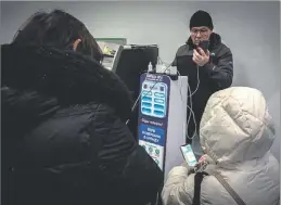  ?? A. LORES ?? Ciudadanos cargando sus móviles en un supermerca­do.