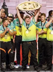  ??  ?? Glen Gillam, who was raised at Neerim South, stands atop the podium holding the world championsh­ip trophy in England.