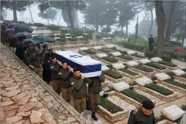  ?? MENAHEM KAHANA — AFP/GETTY IMAGES/TNS ?? Israeli troops carry the coffin of fellow soldier Captain Elkana Vizel during his funeral in the Mount Herzl military cemetery in Jerusalem on Jan. 23, 2024, a day after he was killed in combat in the Gaza Strip amid ongoing battles between Israel and the Palestinia­n militant group Hamas.