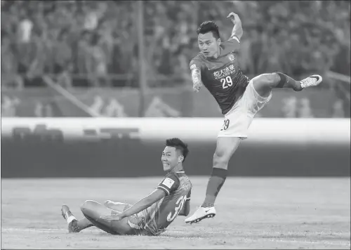  ?? Photo: CFP ?? Guangzhou Evergrande’s Gao Lin ( right) fires a shot against Beijing Guoan during the second leg of their Chinese FA Cup quarterfin­al matchup on Tuesday in Beijing.