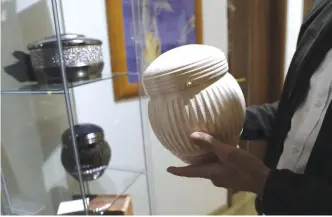  ??  ?? ROME: A man holds an urn at a funeral parlor in Rome yesterday. The Vatican yesterday published guidelines for Catholics who want to be cremated, saying their remains cannot be scattered, divvied up or kept at home but rather stored in a sacred,...