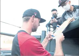  ??  ?? Felton native and San Lorenzo Valley High alum Tyler Gilbert signs autographs at Oracle Park in San Francisco on Tuesday.