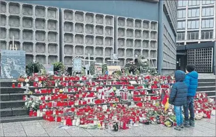  ?? MPL ?? Dos niños observando ayer las velas y flores que siguen recordando a los fallecidos en Breitschei­dplatz