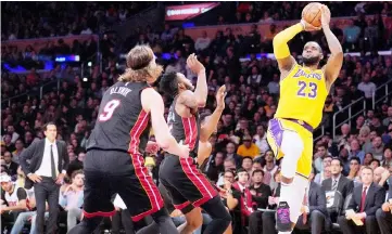  ?? — AFP photo ?? LeBron James (right) of the Los Angeles Lakers attempts a fade away jumper in front of Derrick Jones Jr. (centre) and Kelly Olynyk of the Miami Heat during a 108-105 Laker win at Staples Centre in Los Angeles, California.