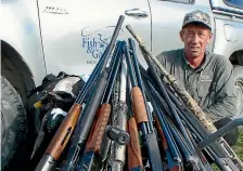  ?? PHOTO: FISH & GAME ?? Fish & Game compliance manager Dirk Barr with guns seized from Waiau hunters found with no licence and using banned ammunition.