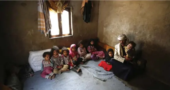  ?? HANI MOHAMMED/THE ASSOCIATED PRESS ?? Faisal Ahmed sits with his nine remaining children at his house in Hazyaz village on the outskirts of Sanaa, Yemen. He blames Saudi-led airstrikes for suffering in Yemen, and for his son’s death.