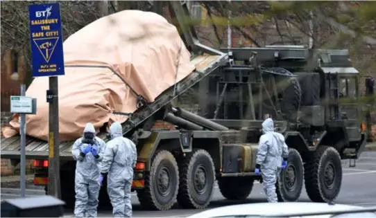  ?? FOTO EPAEFE ?? De Britten nemen geen risico’s: soldaten in beschermen­de pakken en gasmaskers voeren een wagen af die mogelijk werd blootgeste­ld aan het gif.