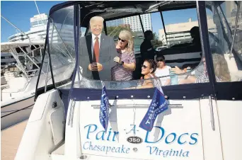  ?? STEPHEN M. KATZ/STAFF ?? Colleen Hoffman and friends show off their life-sized cutout of Donald Trump on Saturday at Norfolk’s Waterside.