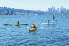  ?? JOHN FROSCHAUER/ASSOCIATED PRESS ?? Friends take to the water of Lake Union in the morning during a heat wave hitting the Pacific Northwest, Sunday, in Seattle. More record highs in the triple digits are expected Monday.