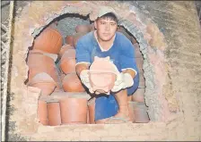  ??  ?? Uno de los artesanos que trabajan con la familia Gaona muestra planteras recién sacadas del horno.