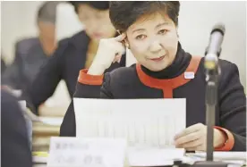  ??  ?? TOKYO: Tokyo Gov Yuriko Koike looks over a report during an expert panel at the Tokyo Metropolit­an government office in Tokyo, yesterday. A Tokyo metropolit­an government panel reviewing costly Olympic venues has proposed downgradin­g the expensive...