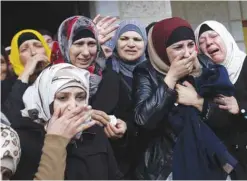  ??  ?? RAMALLAH: Palestinia­n women cry during the funeral of Maan Abu Qara, 23, in the village Mazrah Ghrbeih near the West Bank city of Ramallah yesterday. Abu Qara was killed by Israeli security forces after an alleged stabbing attack at a checkpoint in the...