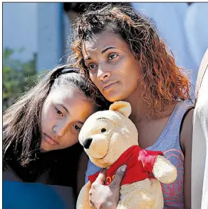  ?? AP/GERALD HERBERT ?? Veronica Laureano and her daughter, Zorayha, 11, attend a vigil Thursday at Parkland Baptist Church in Parkland, Fla., for victims of the shooting Wednesday at Marjory Stoneman Douglas High School.