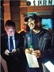  ??  ?? Azis Jamman leaving the MACC office after questionin­g last night. On the left is Darell.