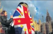  ?? REUTERS ?? An anti-brexit demonstrat­or wears a Union flag decorated with the stars of the EU flag near the British Parliament in London.