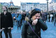  ?? Picture: STR/AFP ?? A woman is one of many who were moved to tears in Paris as they watched Notre Dame cathedral engulfed in flames on Monday.