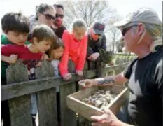  ?? STEVE HELBER — THE ASSOCIATED PRESS ?? In this file photo, Historic Jamestowne staff archaeolog­ist Lee McBee, right, shows artifacts to Carla Howe, of Gilmanton, N.H., left, and her children Caroline, second from left, and Grace, third from left, at the dig site of the Angelo slave house in Jamestown, Va. The first Africans to arrive in North America were so little noted by history that many are known today by only their first names.