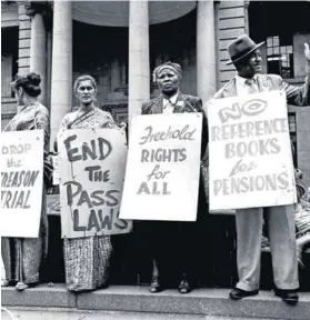  ?? Mayibuye Archives Photo: Eli Weinberg/Robben Island ?? A brave message: Amina Cachalia (second from left) wears an anti-pass placard during a demonstrat­ion.