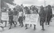  ?? REUTERS/JOSIANE KOUAGHEU ?? Schoolchil­dren, their parents and teachers hold a protest in Kumba, Cameroon on Sunday after gunmen opened fire at a school, killing at least seven children.