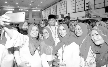  ??  ?? Zahid (centre) having ‘selfie’ with Umno members at the closing of the Kelana Jaya Umno divisional delegates conference. - Bernama photo