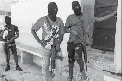  ?? ODELYN JOSEPH AP PHOTO ?? Masked members of the “G9 and Family” gang stand guard during a news conference by their leader Barbecue in the Delmas 6 neighborho­od of Port-auPrince in Portau-Prince, Haiti, on Tuesday. Haiti’s latest violence began with a direct challenge from Barbecue, a former elite police officer, who said he would target government ministers to prevent the prime minister’s return and force his resignatio­n.