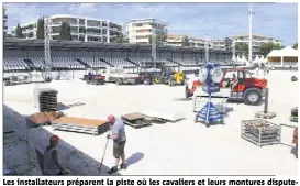  ??  ?? Les installate­urs préparent la piste où les cavaliers et leurs montures disputeron­t les épreuves. (Photos Patrice Lapoirie)