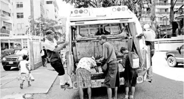  ??  ?? File photo shows children scavenge for food in a rubbish truck in Caracas,Venezuela. — Reuters photo