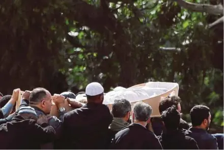  ?? REUTERS PIX ?? The body of a victim being carried during the burial ceremony at the Memorial Park Cemetery in Christchur­ch yesterday.