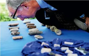  ?? AP AP ?? John Russell, an expert on Iraqi antiquitie­s, looks at cuneiform tablets that are being returned to Iraq.