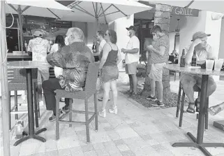  ?? EMMAKATE AUSTIN/SOUTH FLORIDA SUN SENTINEL PHOTOS ?? Max’s Grille in Boca Raton catered to a busy bar area where patrons were not directed to practice social distancing Tuesday.