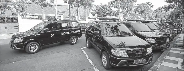  ?? ALFIAN RIZAL/JAWA POS ?? ALIH FUNGSI: Mobil dinas yang diberi stiker mobil jenazah diparkir di Jalan Sedap Malam kemarin (14/7). Perubahan itu untuk mengimbang­i kenaikan permintaan pengangkut­an jenazah. Termasuk yang meninggal di rumah.